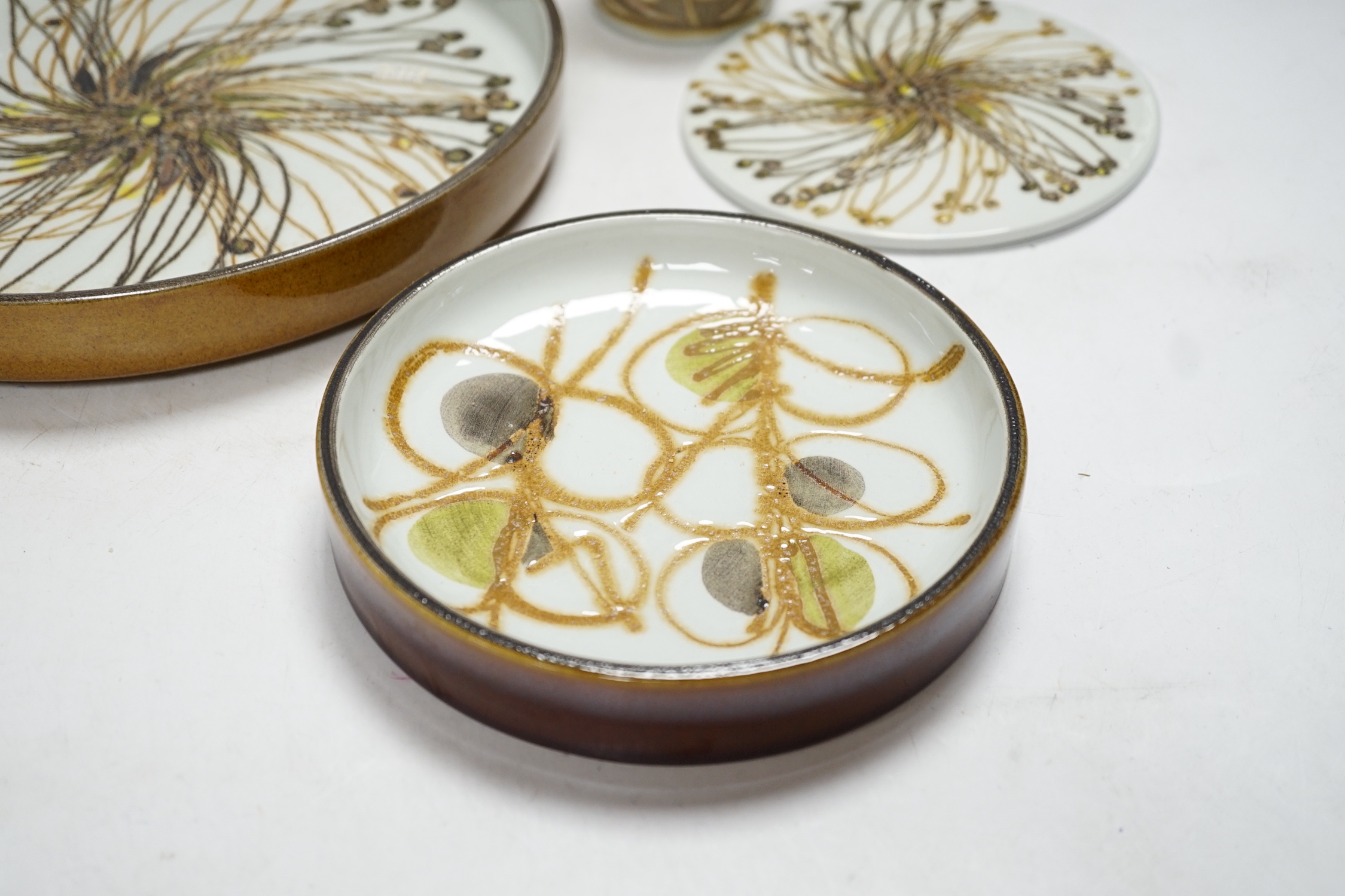 Seven Royal Copenhagen fajance items; a vase decorated with birds, a vase, decorated with fish, a small pot, a holder, two circular dishes and a teapot stand, largest dish 26cm diameter